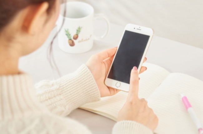 情報を調べながら考える人の写真